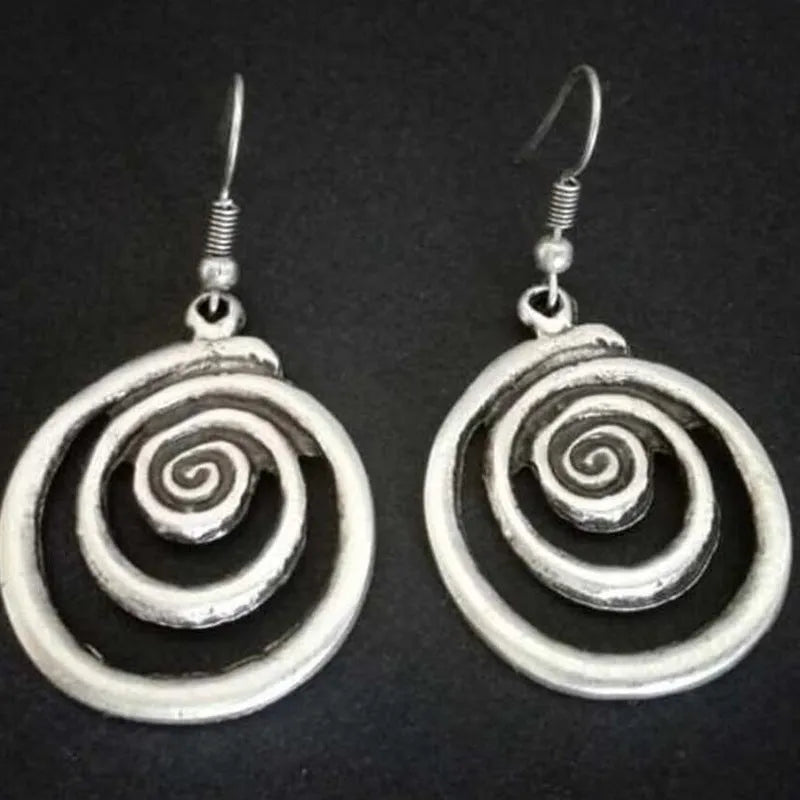 Geometric spiral distressed silver alloy drop earrings on a white background.