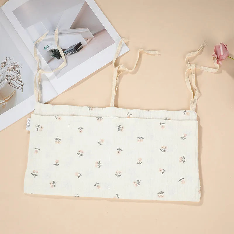 Cotton double layer baby bedside buggy bag in camel colour with tie straps attached to a pram handle