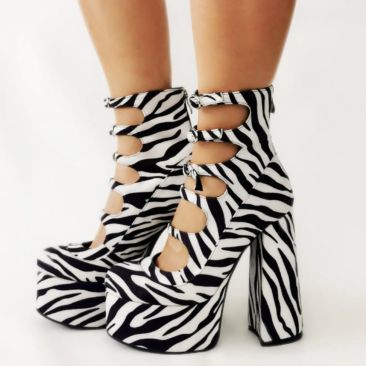 Black patent leather women's ankle boots with a platform, thick block heel, and a serpentine buckle strap around the ankle.