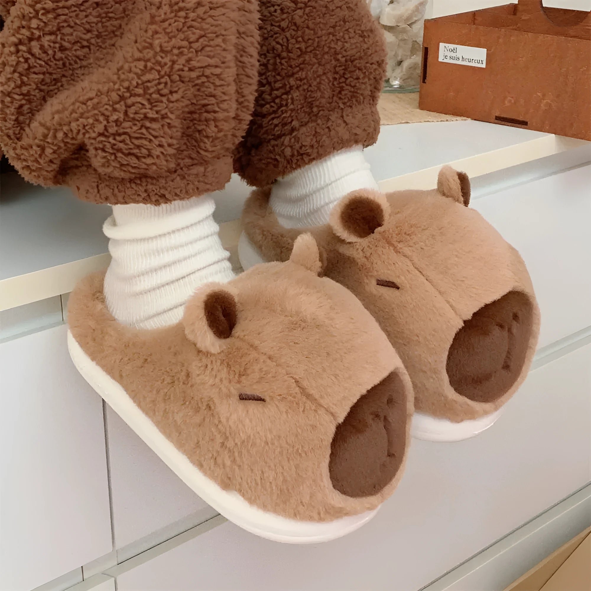 Cartoon Capabala cotton slippers with brown suede upper and round toe, shown on a light indoor floor