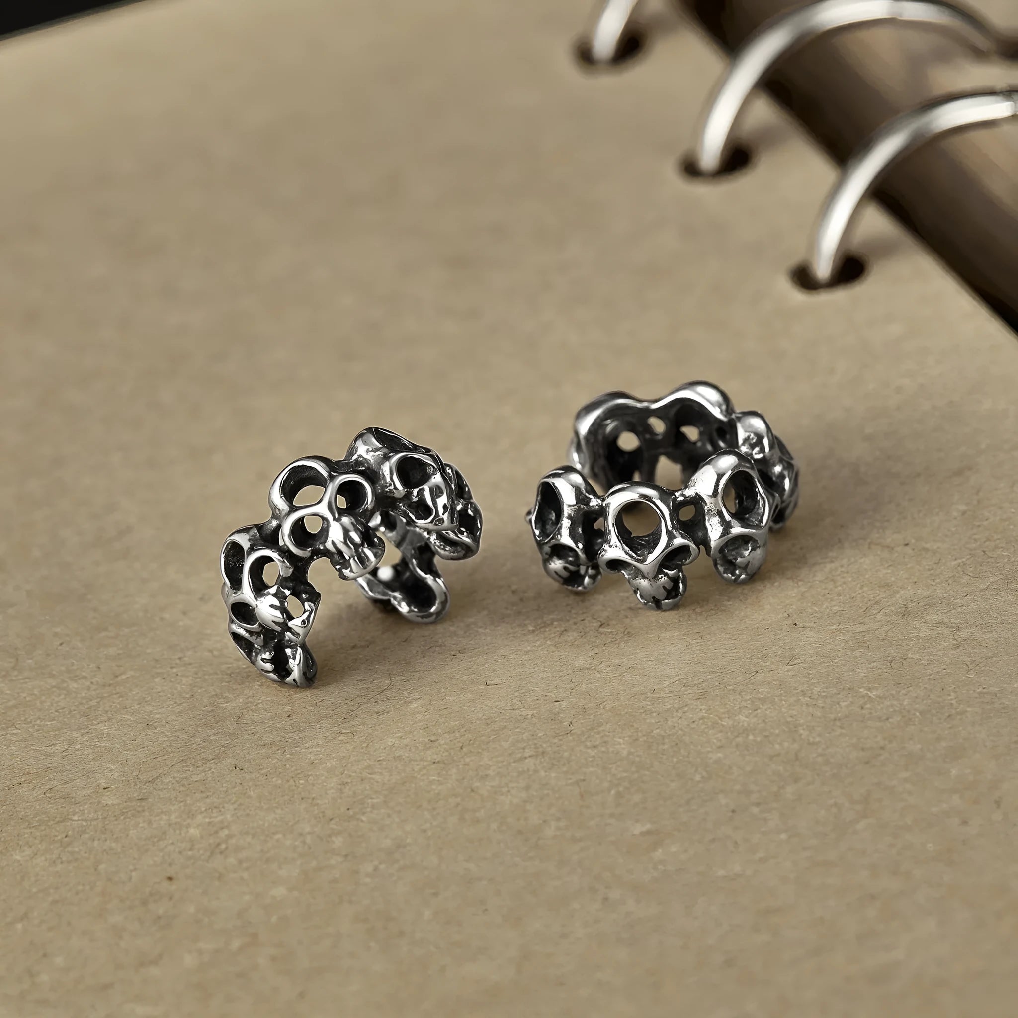 Stainless steel clip-on earrings featuring a hollow geometric skull design with an electroplated finish.