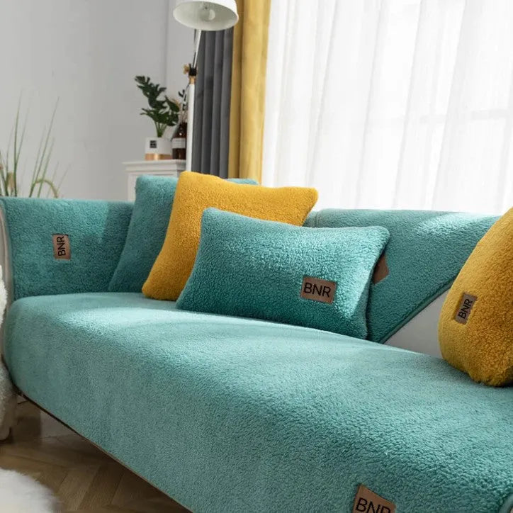 Lambswool solid colour sofa cover in blue on a grey sofa