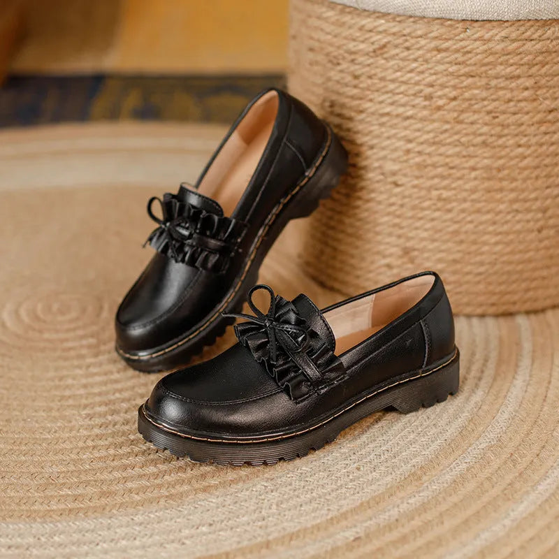 Women's black leather shoes with round toe and chunky flat heel on white background