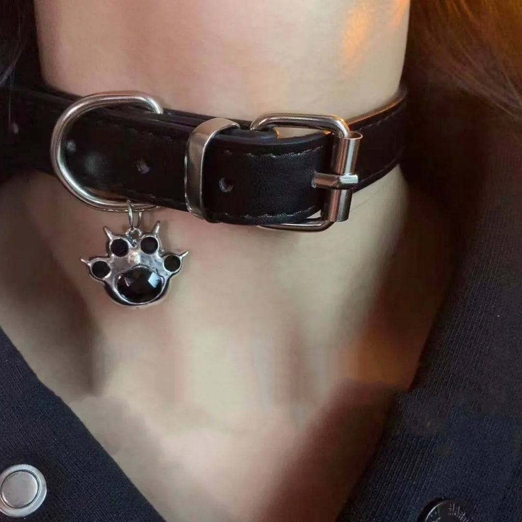 Black leather dog collar with regular chain closure, adjustable from 21cm to 50cm, available in cat paw or bone designs.