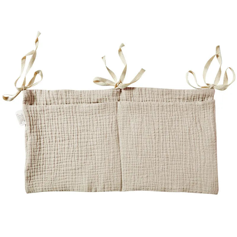 Cotton double layer baby bedside buggy bag in camel colour with tie straps attached to a pram handle