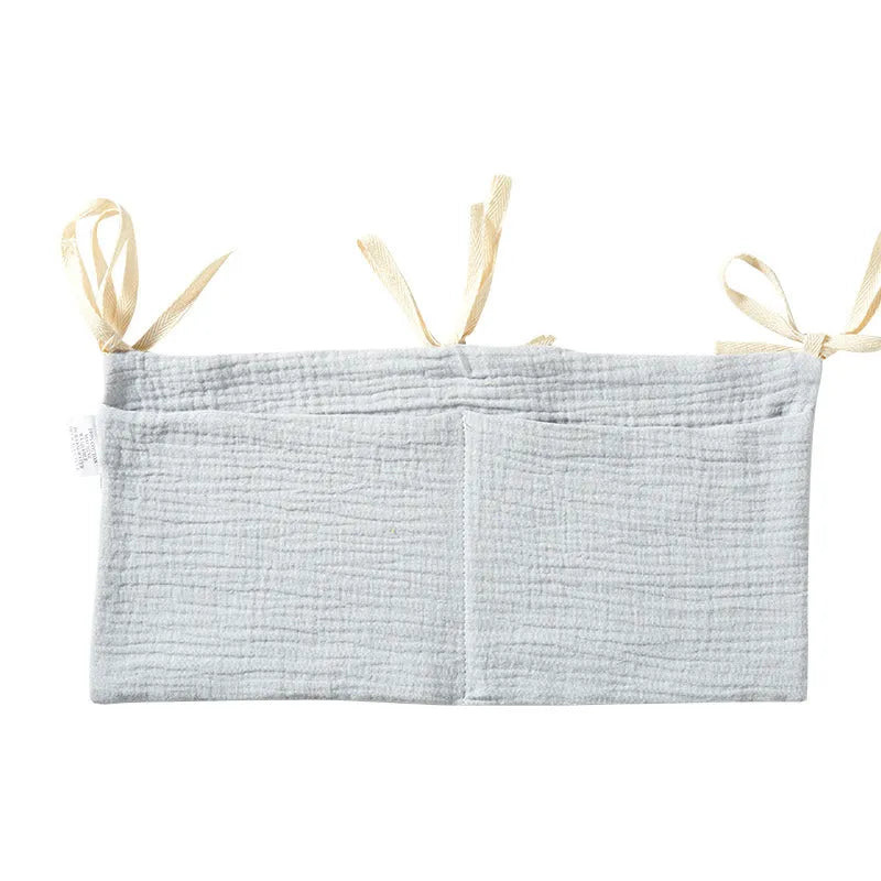 Cotton double layer baby bedside buggy bag in camel colour with tie straps attached to a pram handle