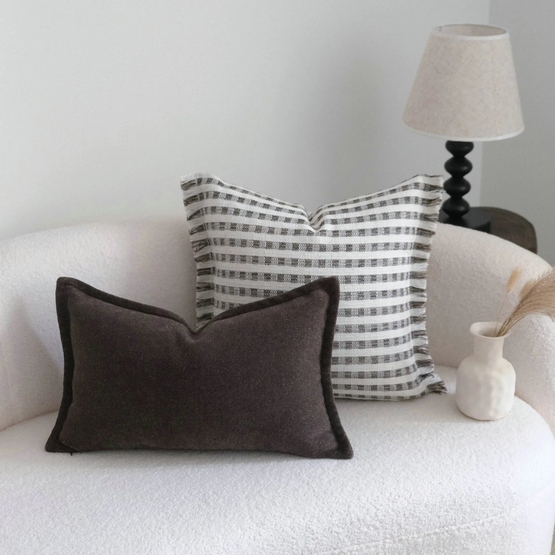 Coffee brown striped mid-century sofa cushion in Chinese classical style on a grey sofa.