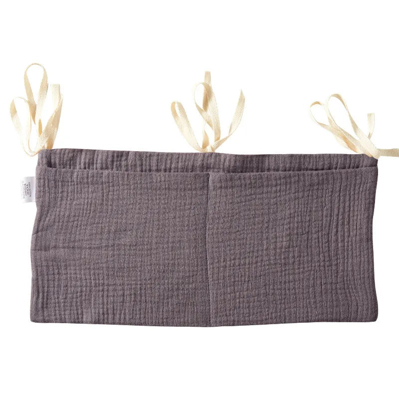 Cotton double layer baby bedside buggy bag in camel colour with tie straps attached to a pram handle