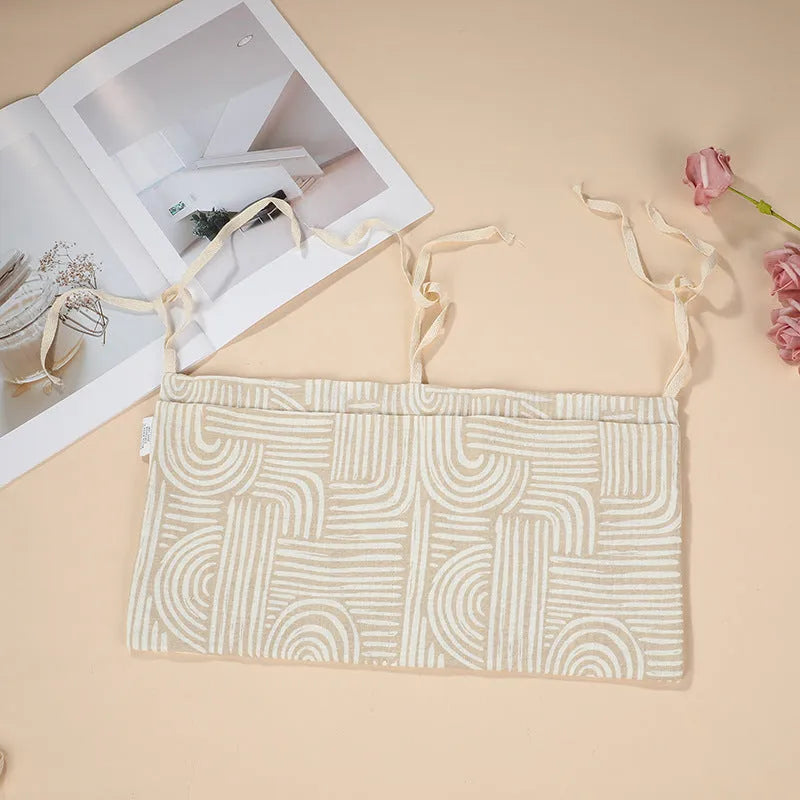 Cotton double layer baby bedside buggy bag in camel colour with tie straps attached to a pram handle