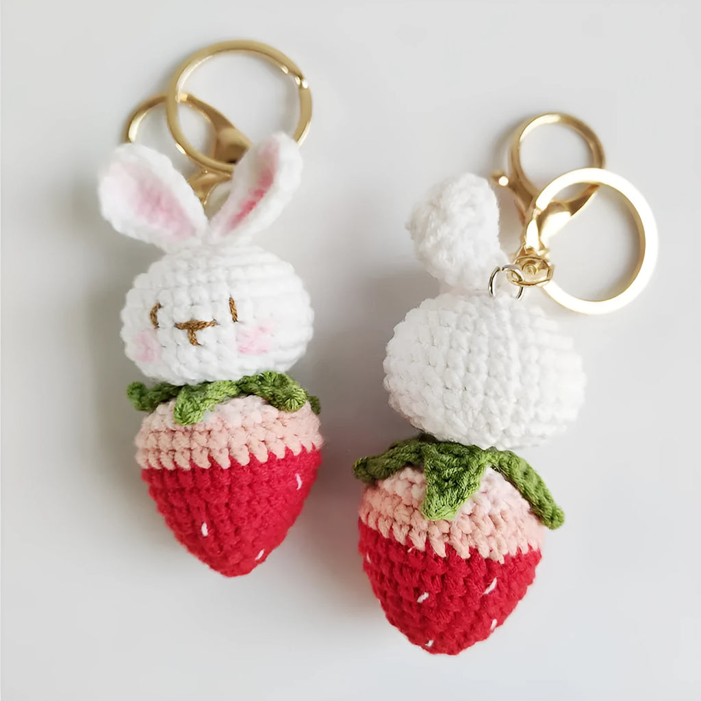 Hand-woven white wire pendant with rabbit and strawberry cartoon pattern, shown with a key attachment.