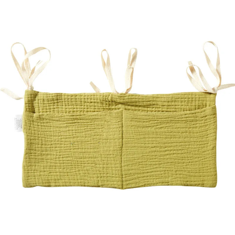 Cotton double layer baby bedside buggy bag in camel colour with tie straps attached to a pram handle