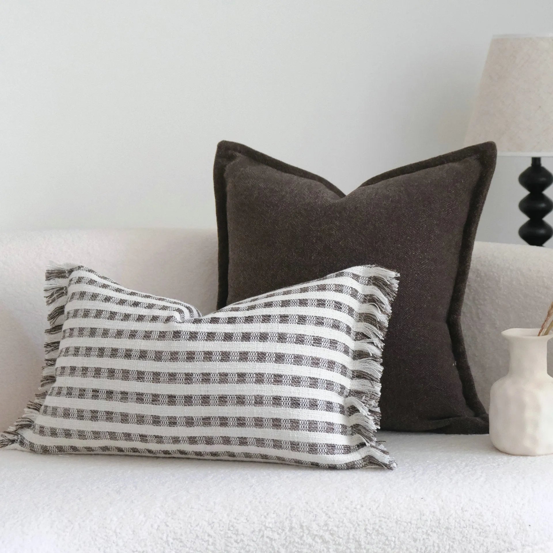 Coffee brown striped mid-century sofa cushion in Chinese classical style on a grey sofa.