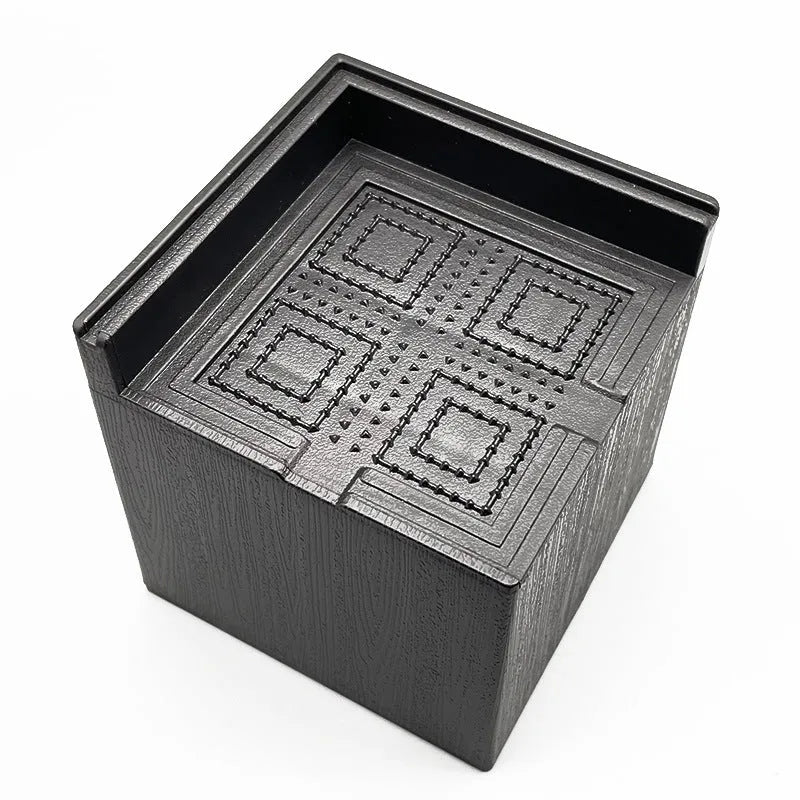 Four black thickened plastic furniture foot height increasing mats on a white background