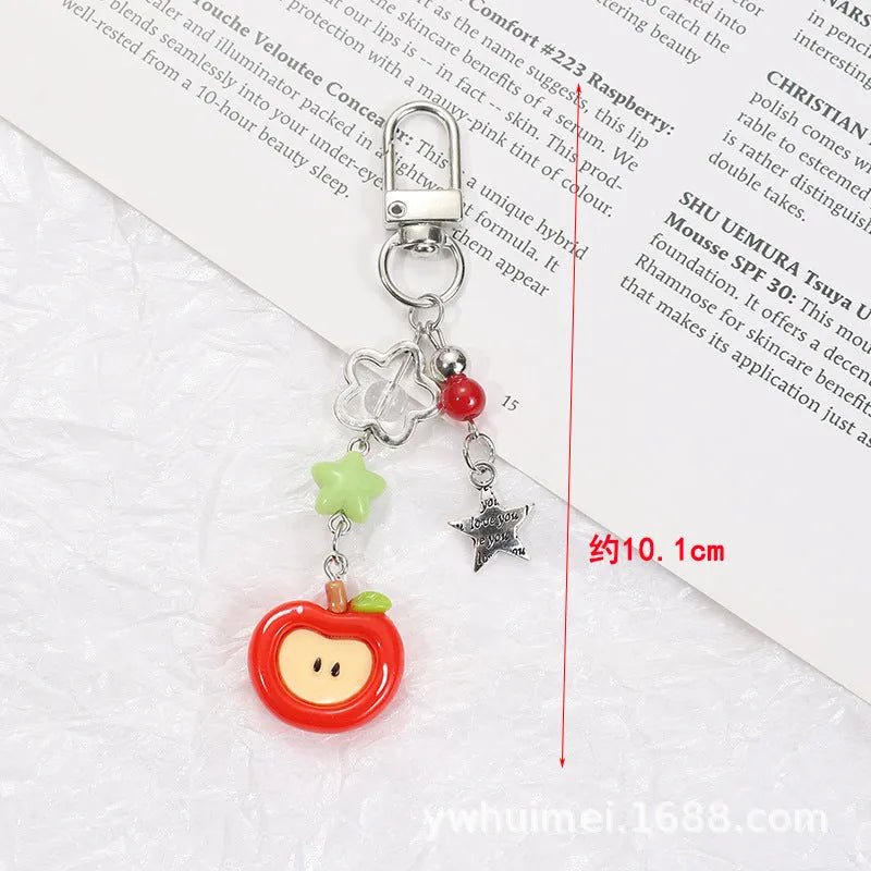 Plastic resin fruit phone charm keychain with strawberry design on white rope cord
