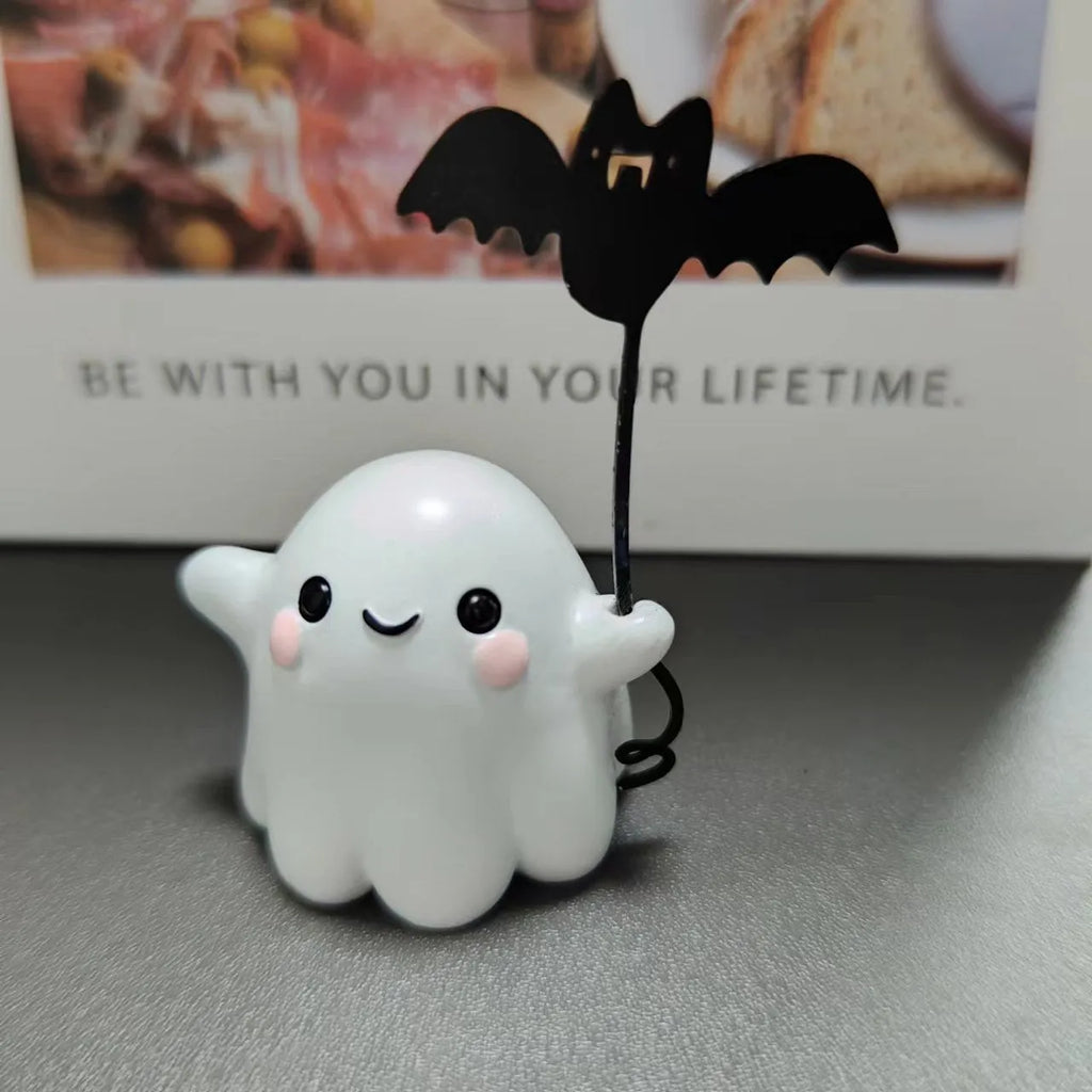 Small resin statue of a ghost walking a dog and holding a bat, a mini Halloween ornament.