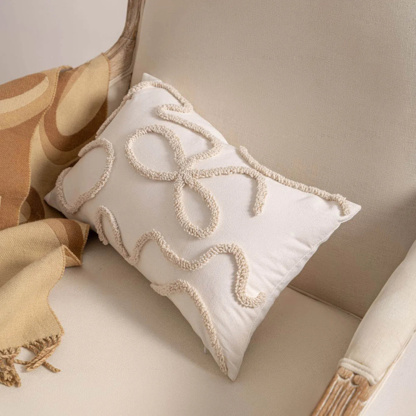 Knitted striped cushion cover with tassel trim in 45x45cm size on a sofa.