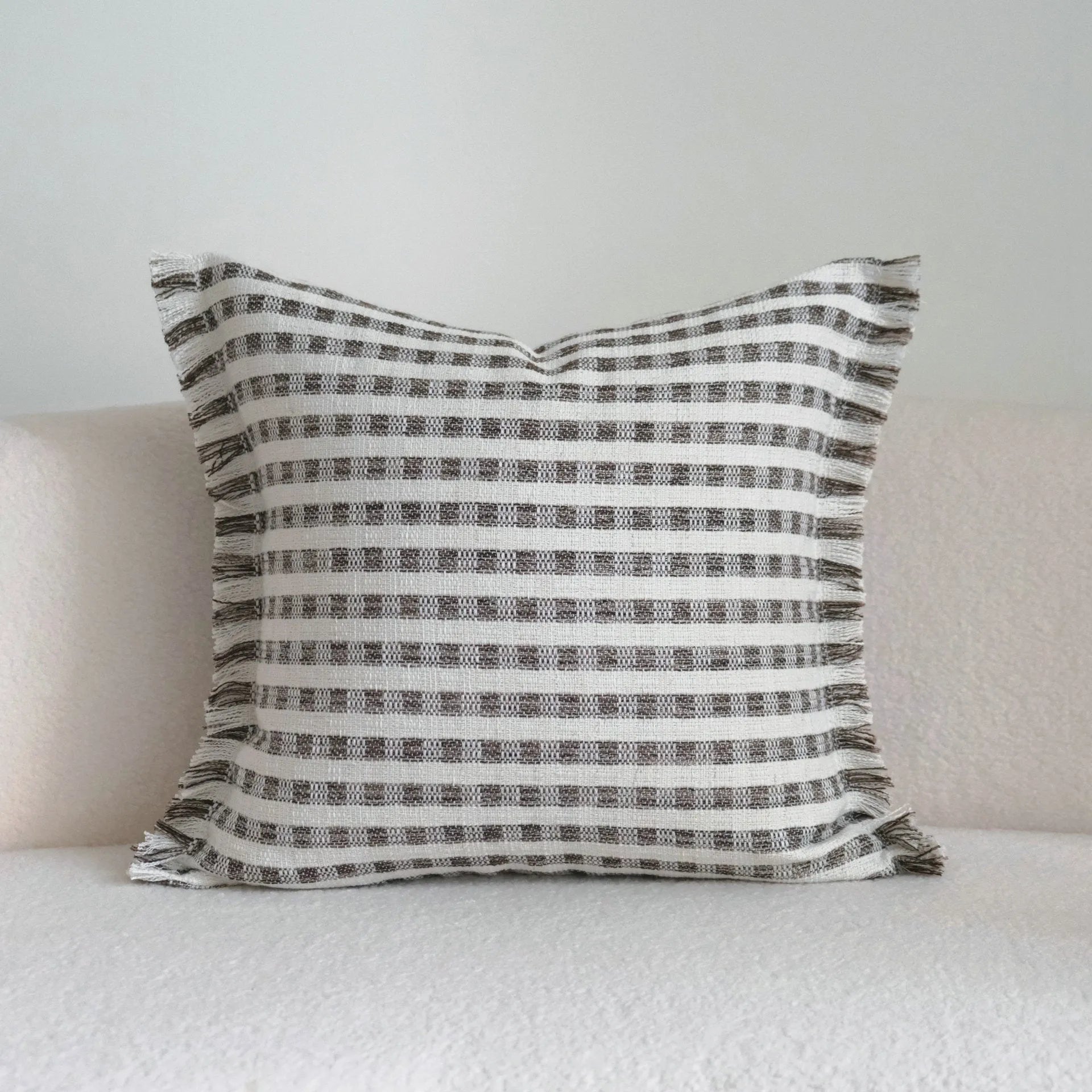 Coffee brown striped mid-century sofa cushion in Chinese classical style on a grey sofa.