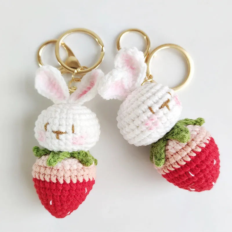 Hand-woven white wire pendant with rabbit and strawberry cartoon pattern, shown with a key attachment.