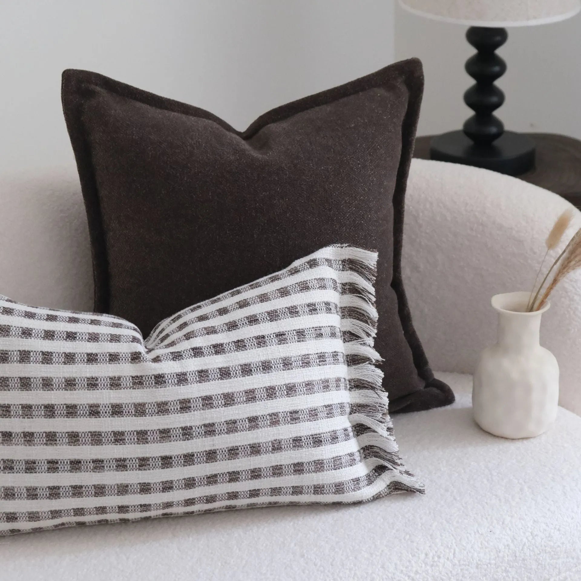 Coffee brown striped mid-century sofa cushion in Chinese classical style on a grey sofa.