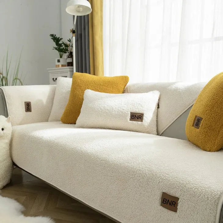 Lambswool solid colour sofa cover in blue on a grey sofa