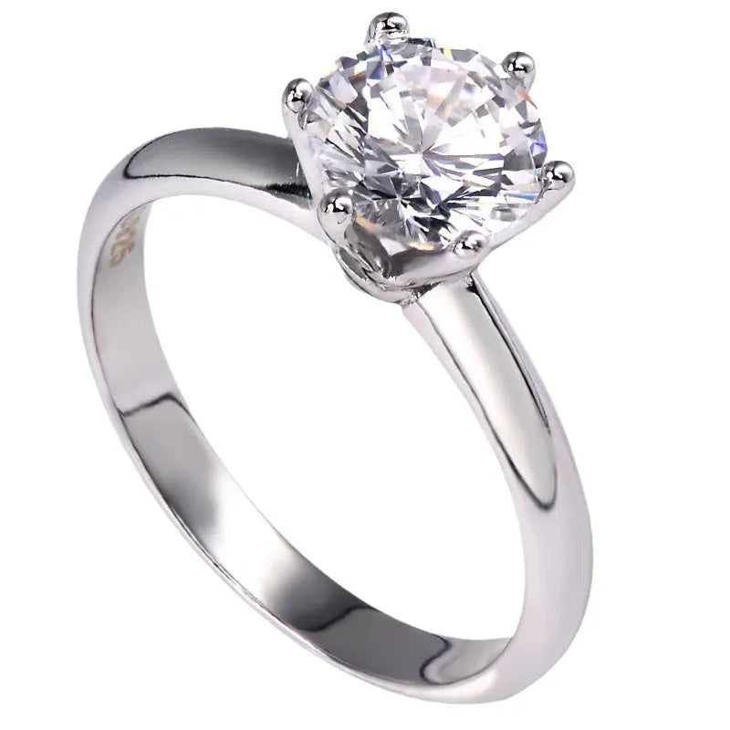 White gold plated six-claw zircon women's ring with geometric shape on a finger.