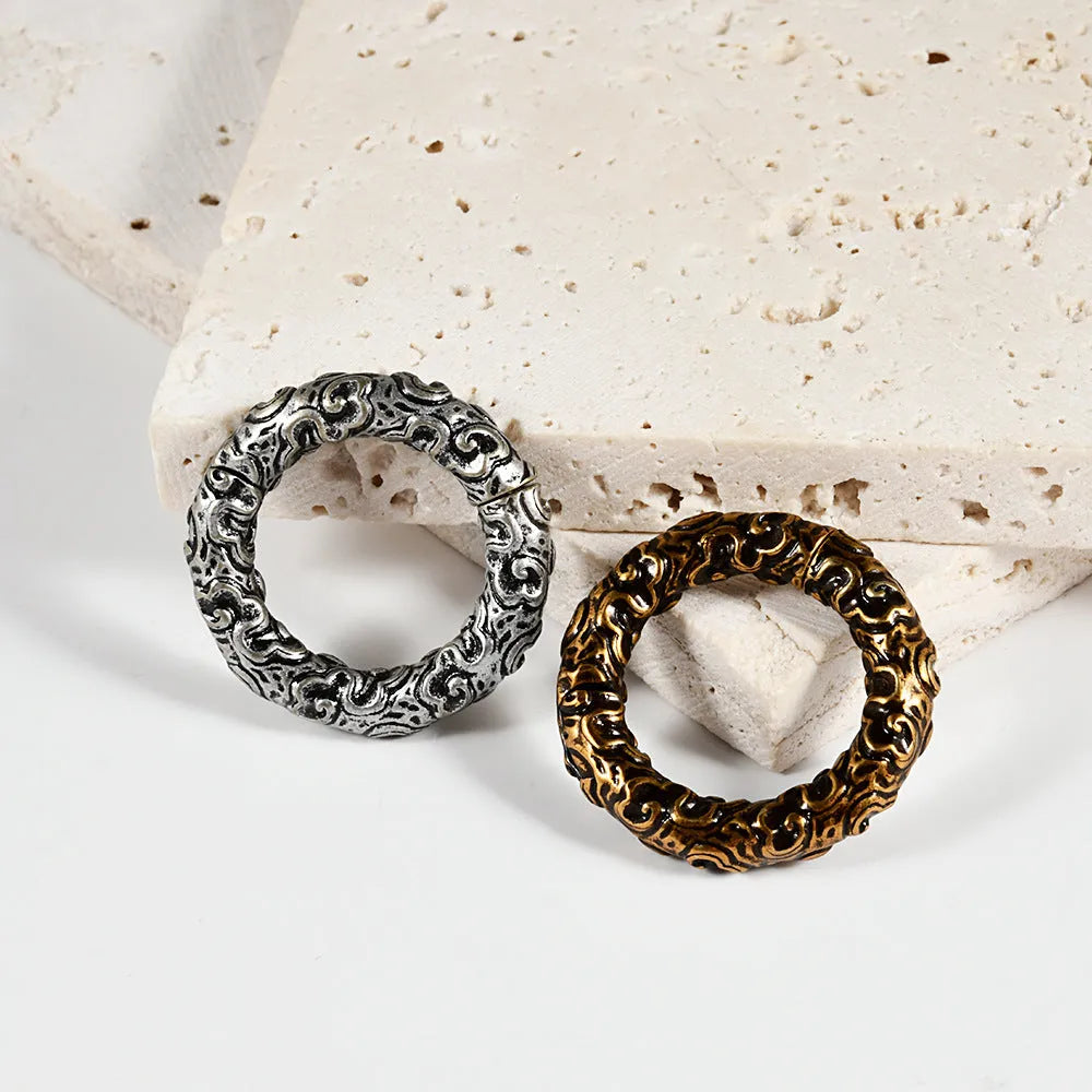 A pair of stainless steel totem pattern earrings with an electroplated finish, shown from the 15 available style options.