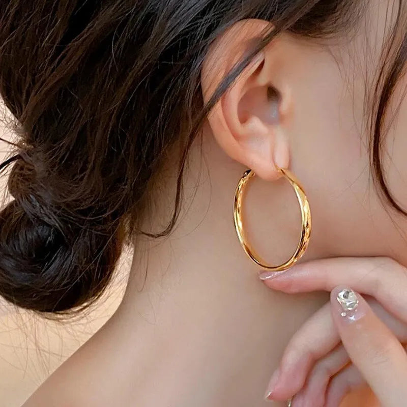 A pair of circular open-ring metal earrings in a gold or silver finish, measuring 40mm.