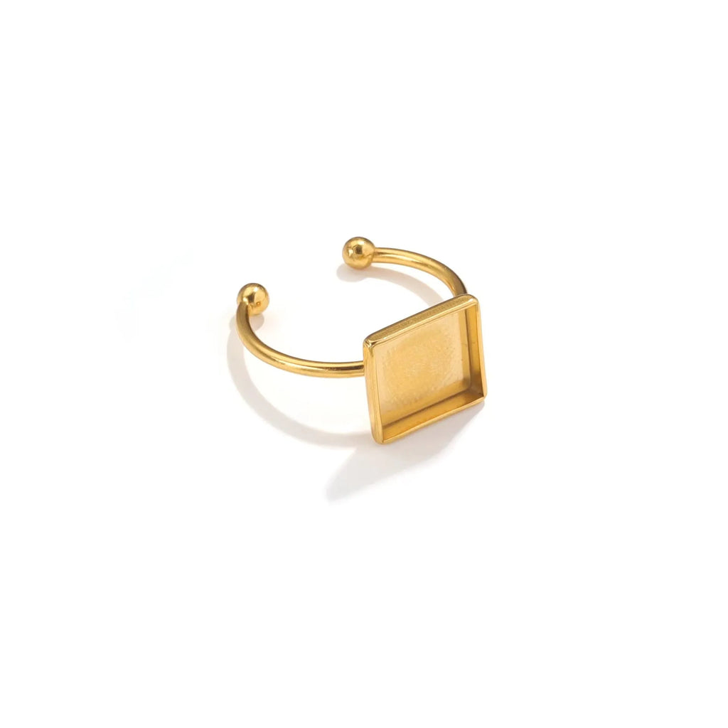 Assortment of golden stainless steel DIY jewellery settings in oval, heart, round, square, and rectangle shapes with totem pattern.