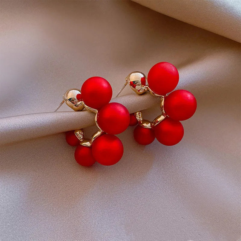 Red bell-shaped alloy drop earrings for women on a white background.
