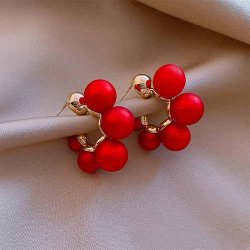 Red bell-shaped alloy drop earrings for women on a white background.