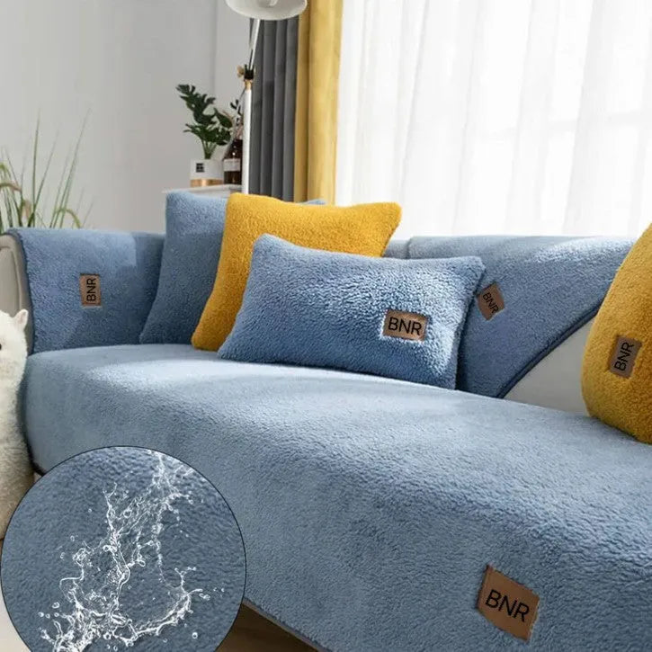 Lambswool solid colour sofa cover in blue on a grey sofa