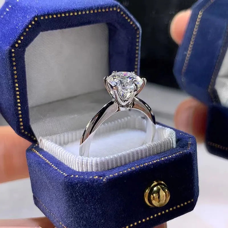 White gold plated six-claw zircon women's ring with geometric shape on a finger.