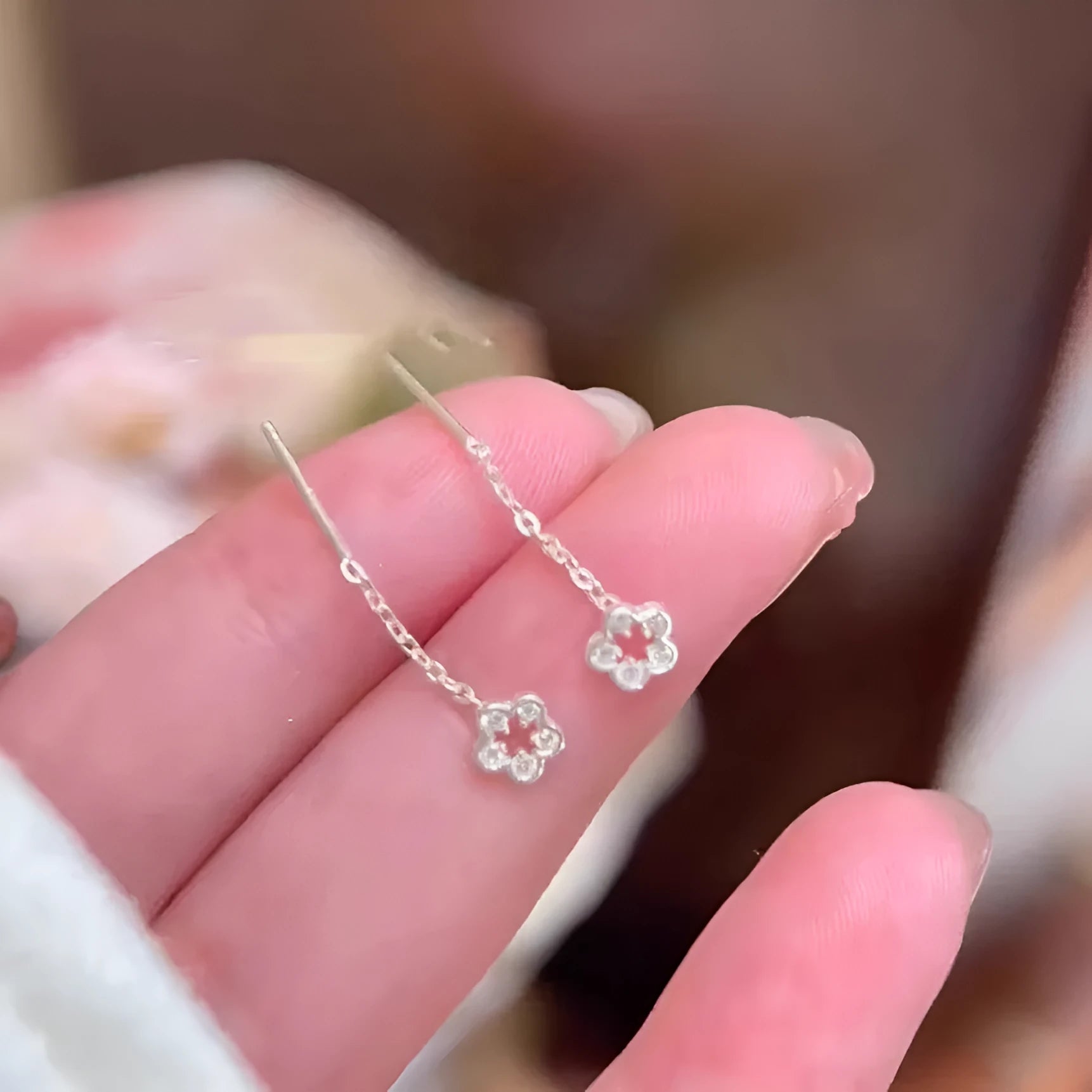 Silver flower hanging earrings with hollow petal design and stud backings