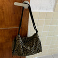 Sports style shoulder messenger bag in leopard print or stripes pattern with crossbody strap