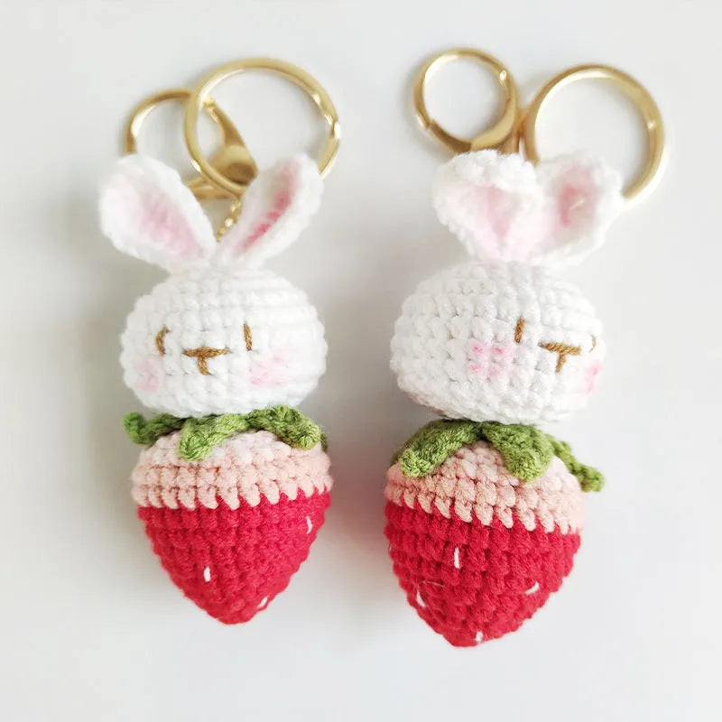 Hand-woven white wire pendant with rabbit and strawberry cartoon pattern, shown with a key attachment.