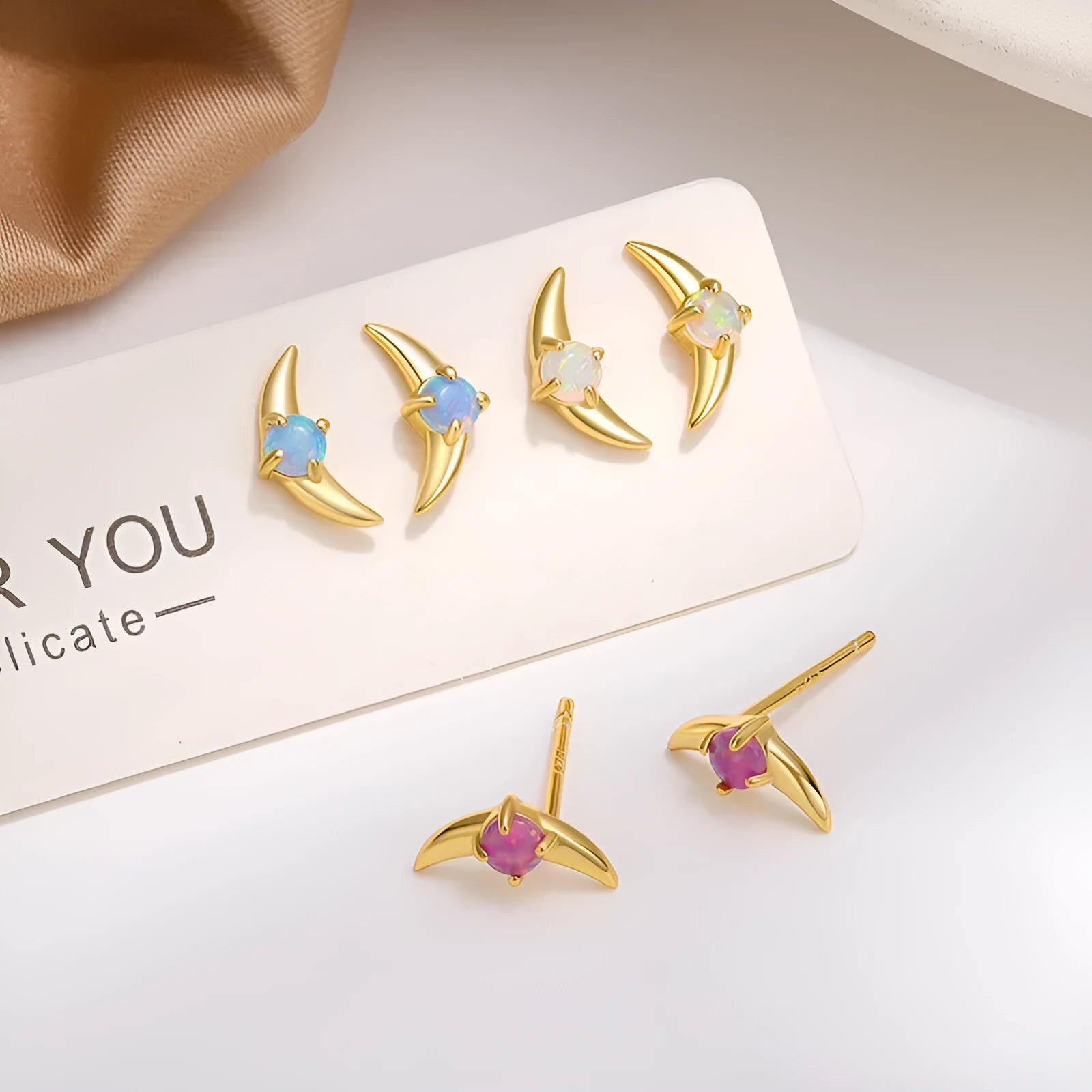 Geometric women's earrings in 925 silver with gold or platinum finish and blue, purple, or white stone.