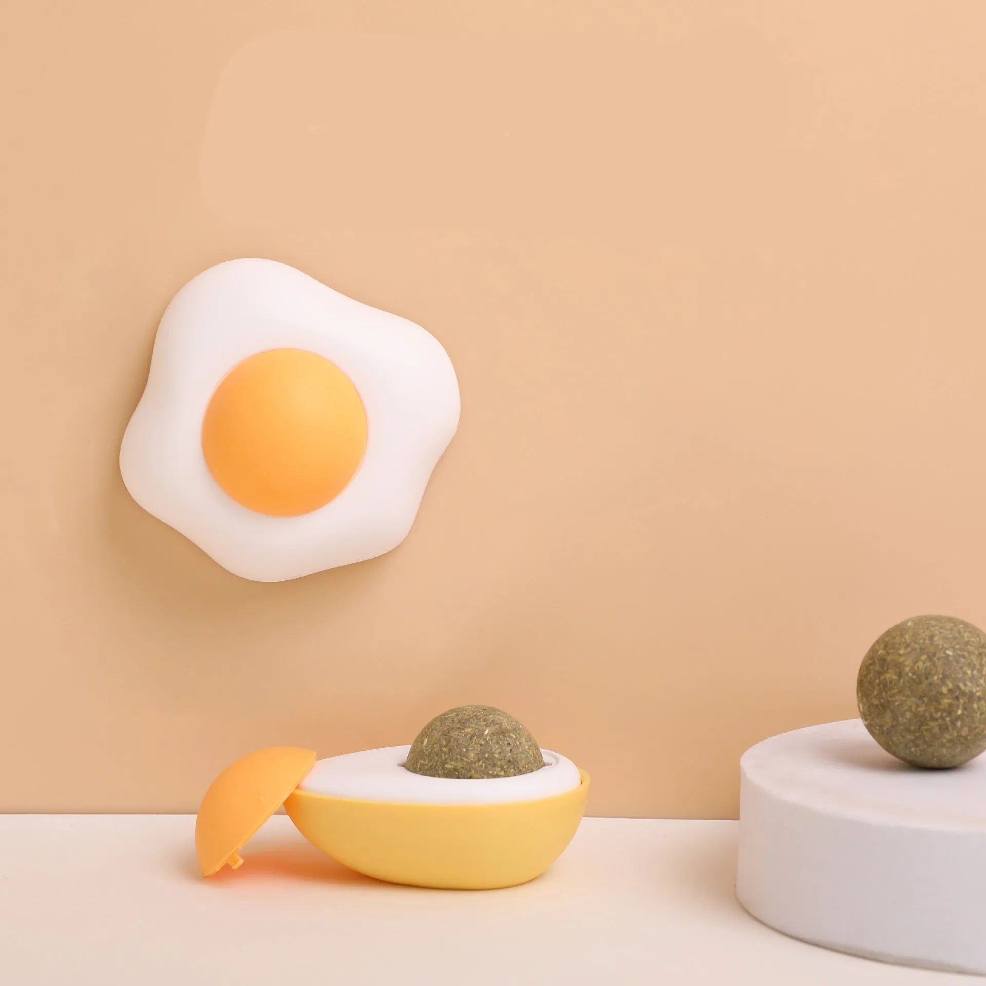Interactive catnip ball toy with soft plush exterior mounted on wall surface
