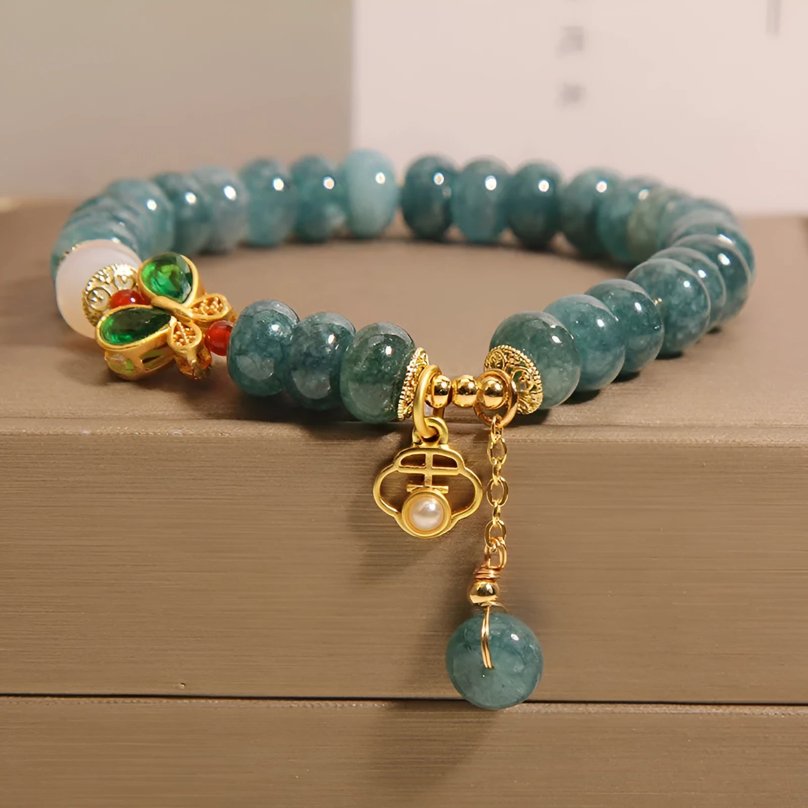 Blue water jade abacus bead bracelet with white agate and butterfly charm design