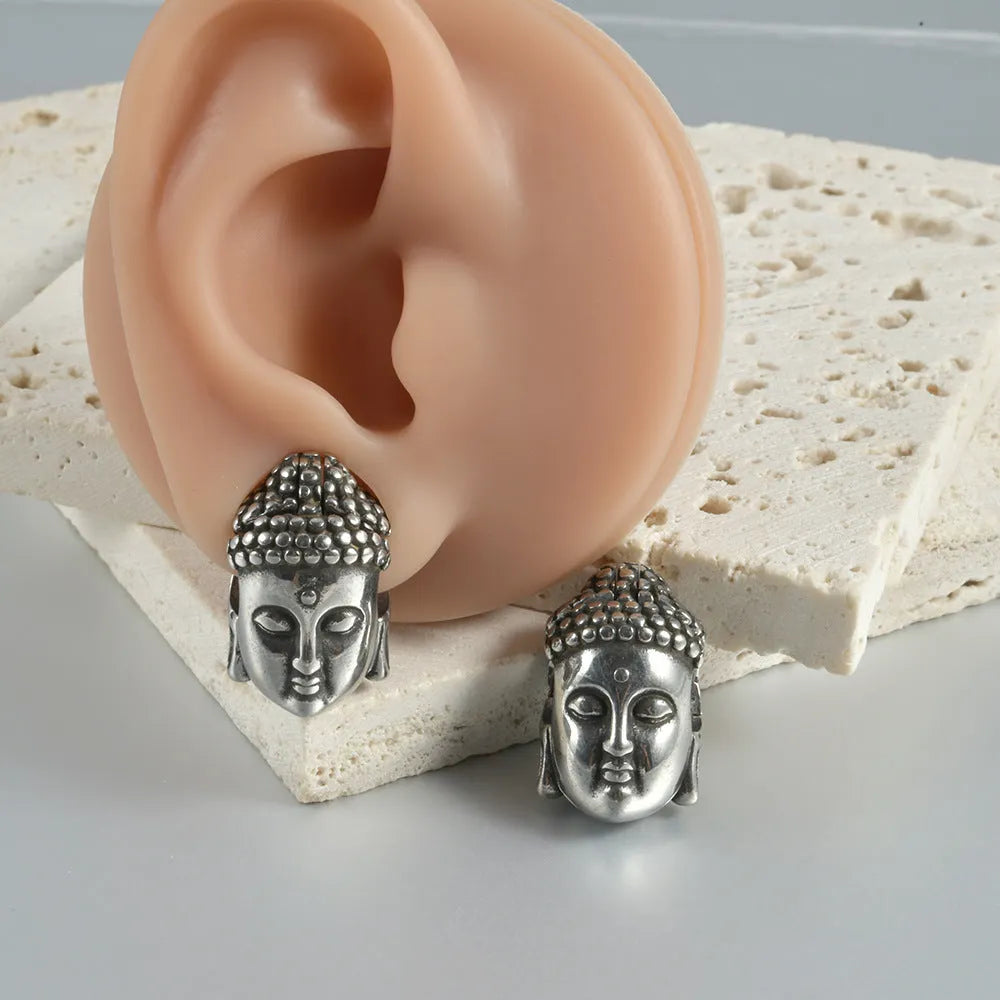 Stainless steel hollow skull Buddha earrings showing four colour finishes on geometry design