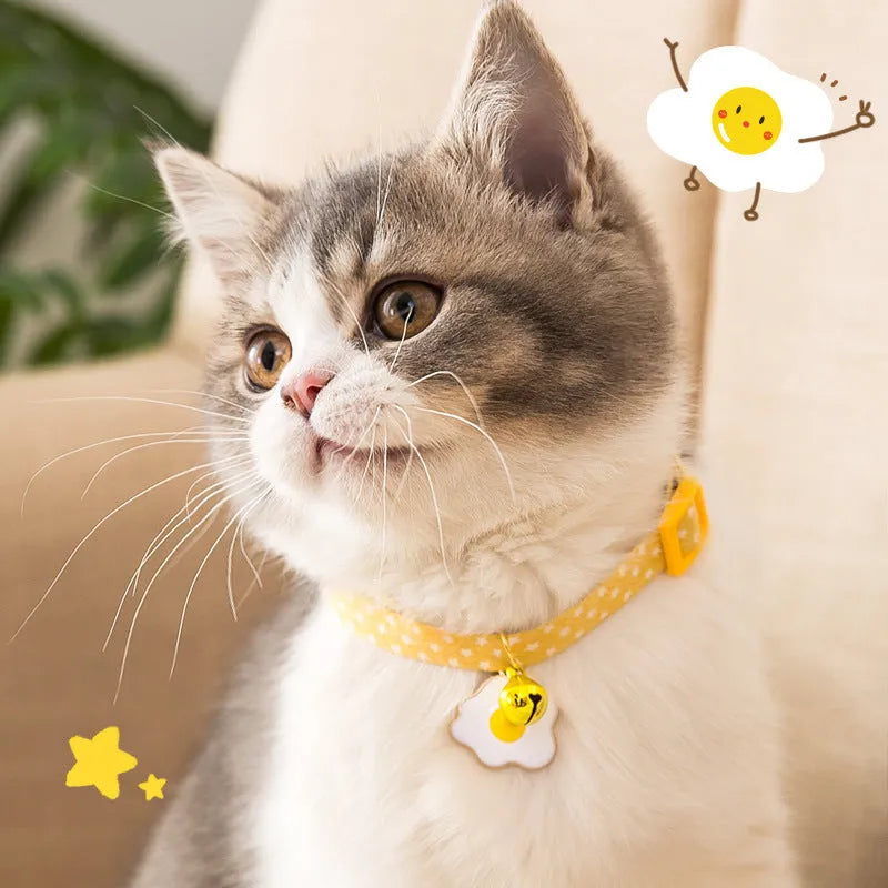 Green adjustable pet collar with a metal bell pendant and a matching bow tie on a white background.