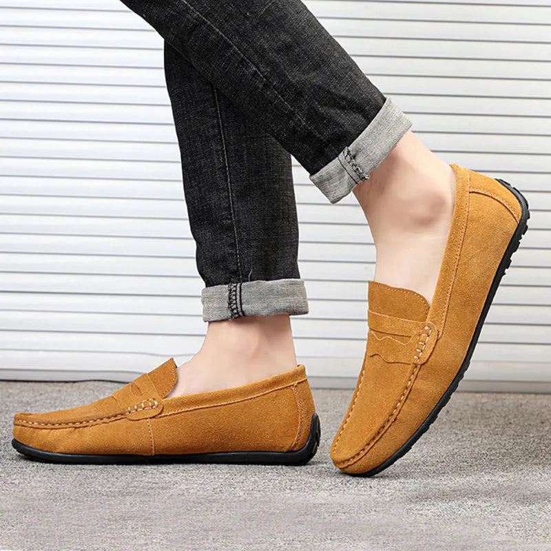 Men's solid colour suede loafers with round toe and rubber sole on a neutral background.