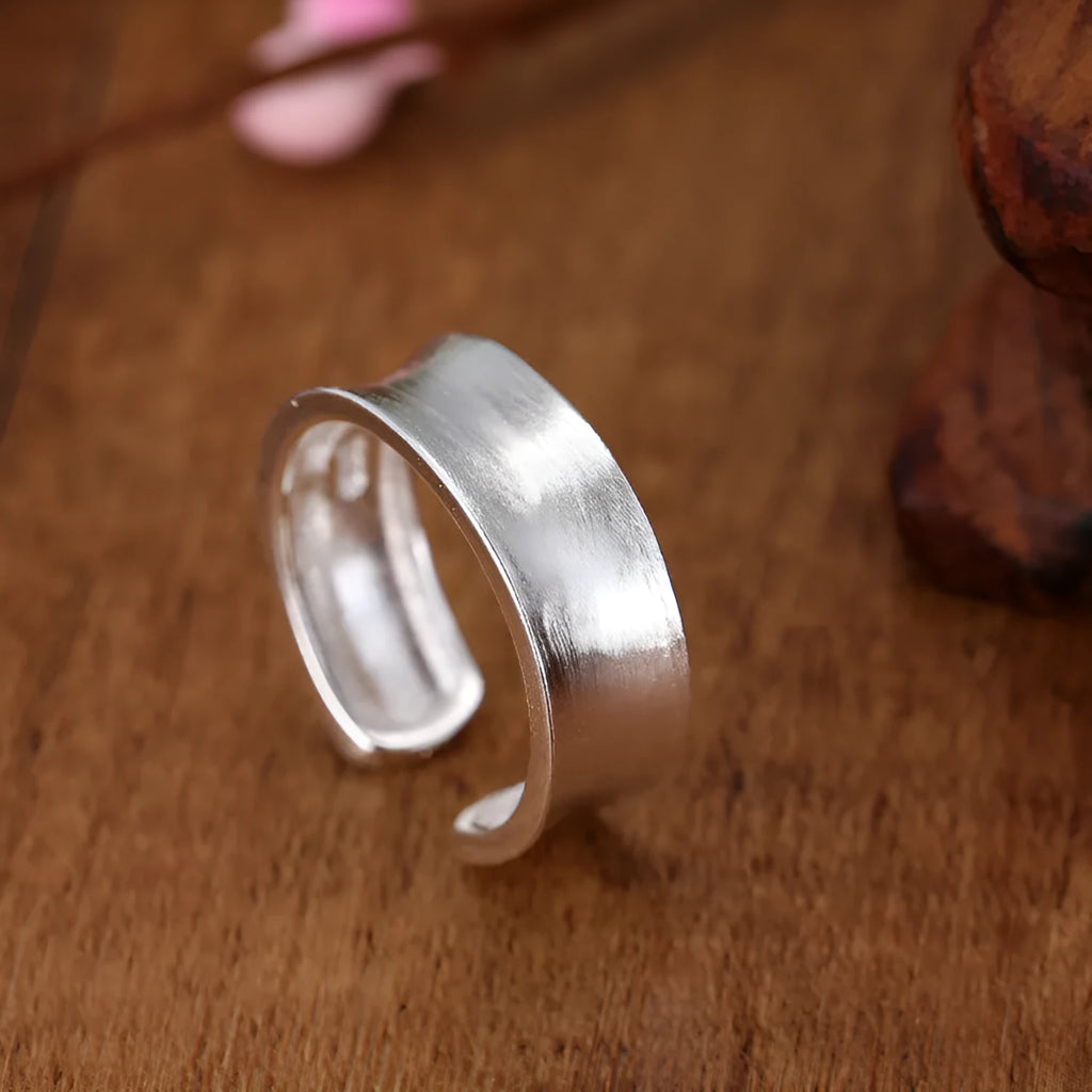 Frosted silver geometric open ring with adjustable sizing on a neutral background