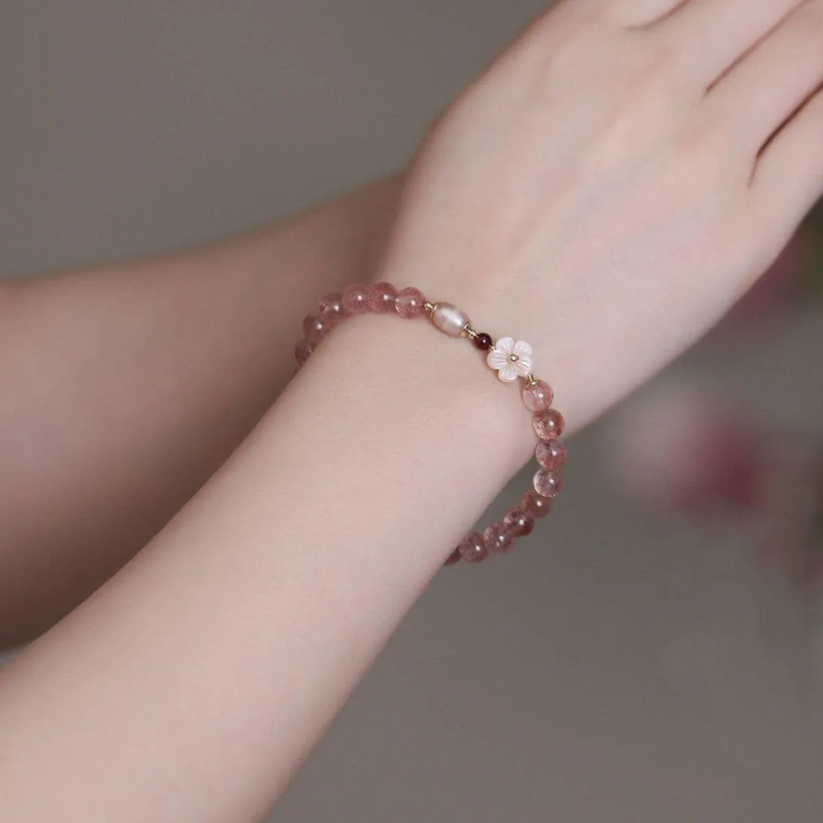 Strawberry quartz peach blossom bracelet with crystal flower charm and gemstone beads.