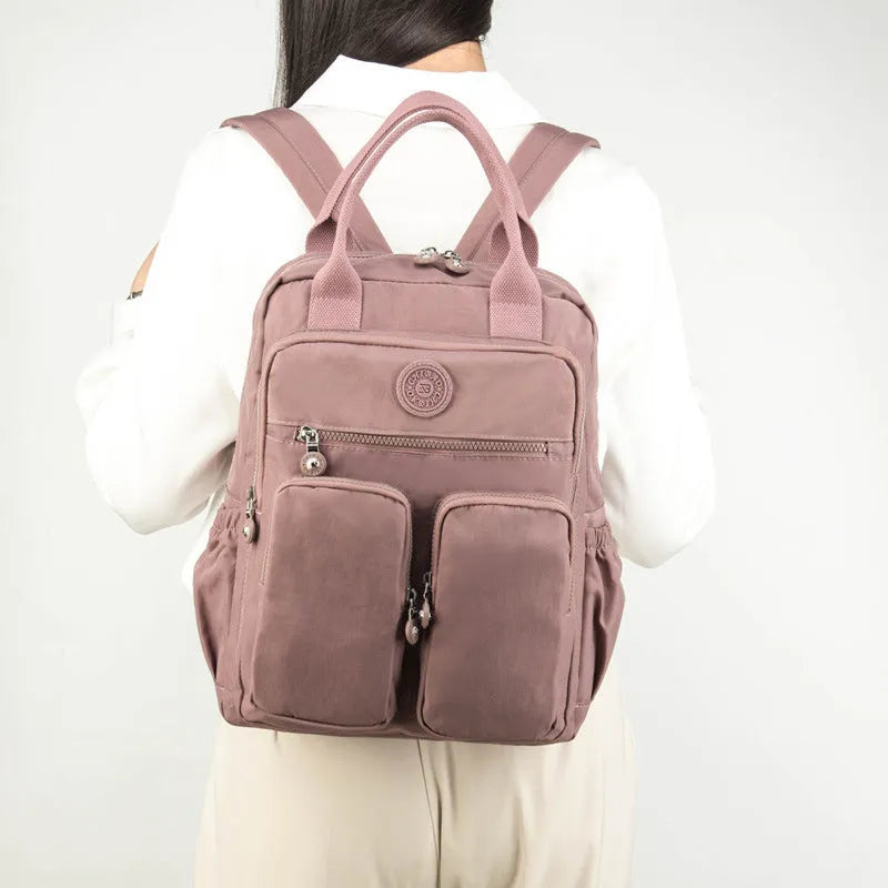 Women's waterproof nylon travel backpack with multiple internal compartments in various colours