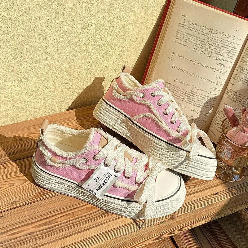 Women's low-top canvas shoes in solid colour with vulcanised rubber sole, available in beige, black, and pink.