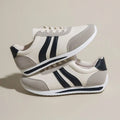 Low-top blue and red lace-up sneakers with mesh upper and rubber sole on a white background