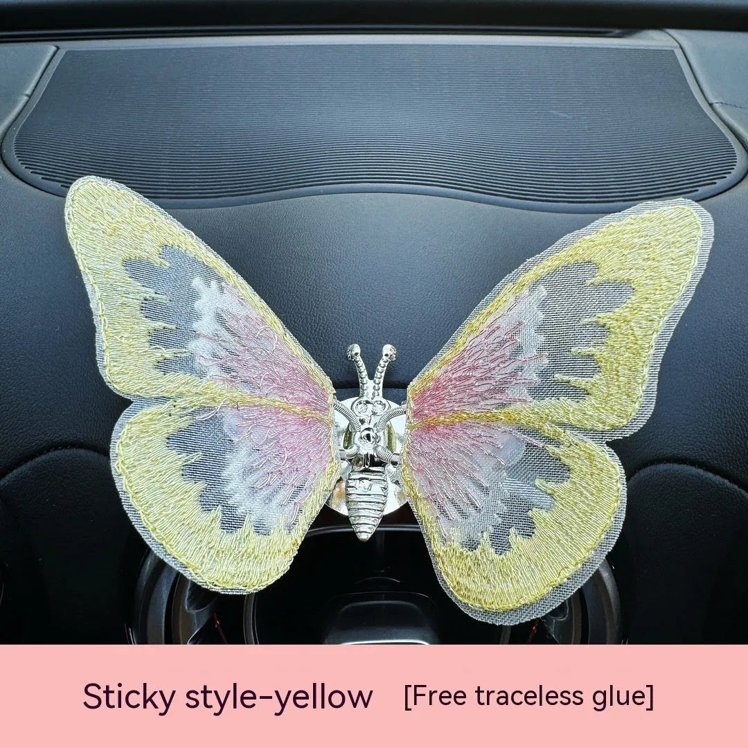 Moving embroidery butterfly decoration on car centre console air vent in pink fabric