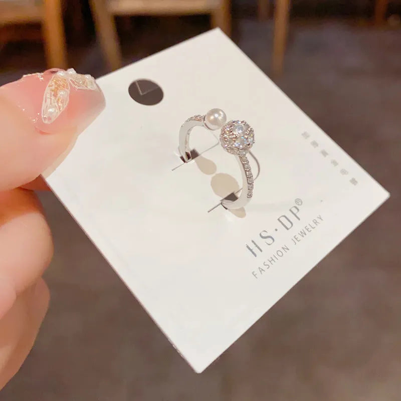 Gold and silver open-end women's ring with round zircon stones and pearl design on geometric band