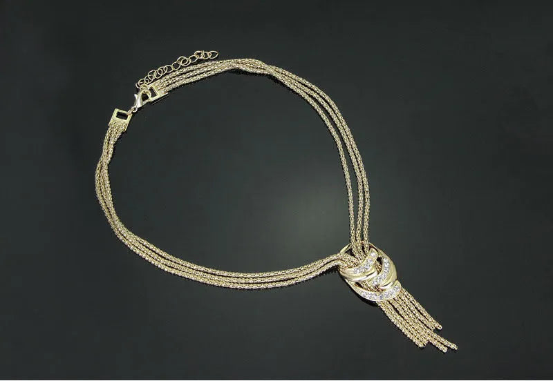 Gold alloy jewelry set with necklace, bracelet, earrings, and ring on a neutral background