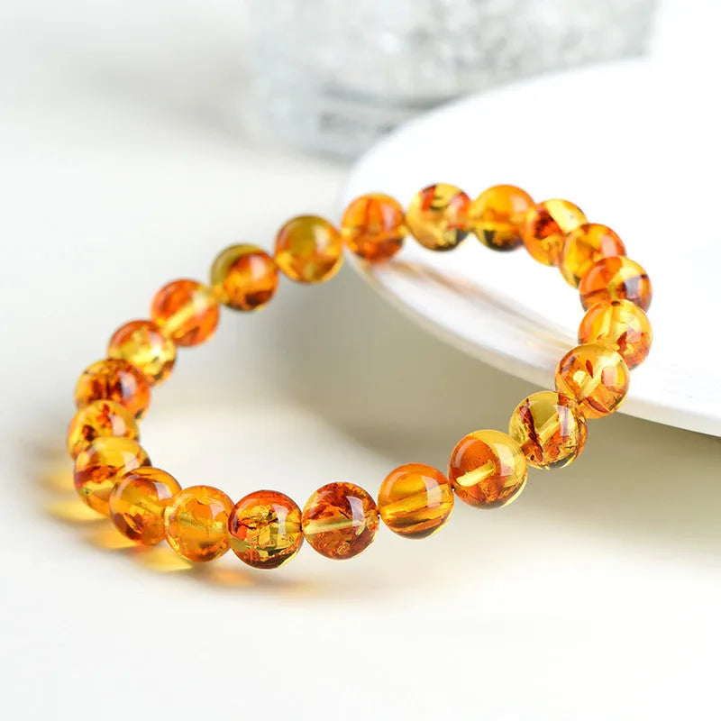 Yellow piebald amber bracelet with geometric beads showing natural flower spot patterning